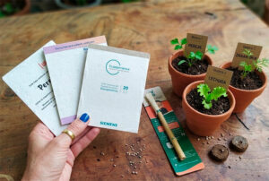 Kit con escarapela y bolígrafo germinable personalizado para eventos, congresos y regalos corporativos ecológicos.